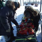 Man dressed in fus filling gas can on a snowmachine